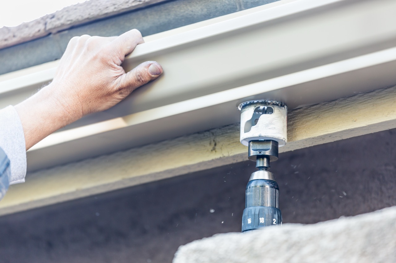Close-up of detailed gutter work being performed on a residential building — the kind of precision finish-out that Hackensack's older multi-era housing stock requires.