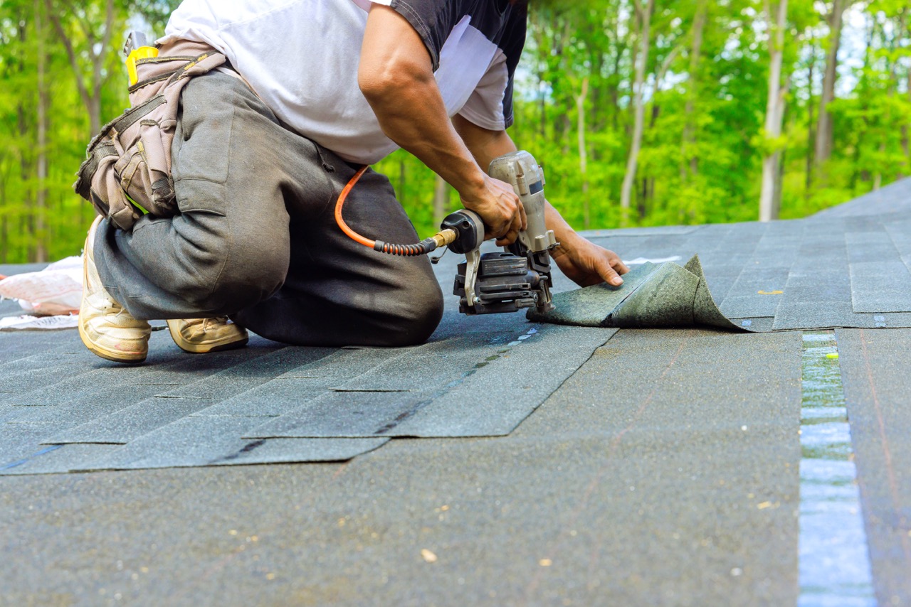 Hand-installation of new roofing material — the kind of detail work that distinguishes a proper flat-roof termination from a quick patch.
